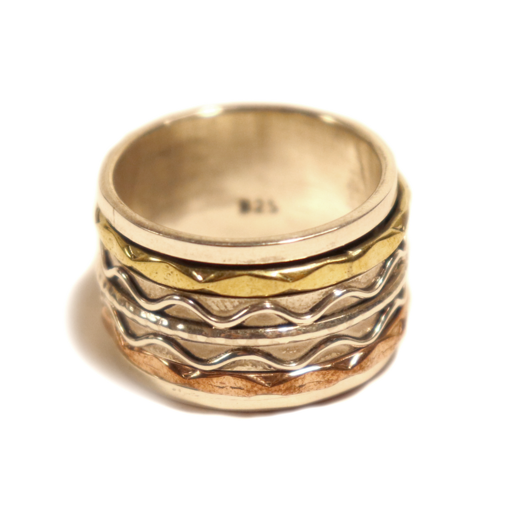 silver and brass spinning meditation ring.  3 rings move around a wide ring